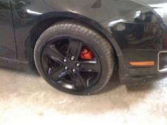 stock rims painted black, with red calipers.
